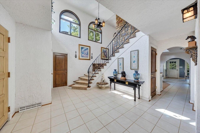 5880 Sugar Loaf Mountain Rd, Roanoke, VA 24018 - foyer with a textured wall, a textured ceiling, arched walkways, a chandelier, and stairs