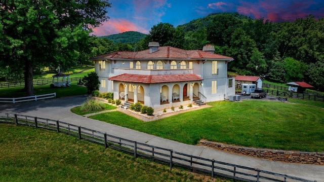 5880 Sugar Loaf Mountain Rd, Roanoke, VA 24018 - back of house at dusk with a porch, a chimney, asphalt driveway, an outbuilding, and stucco siding