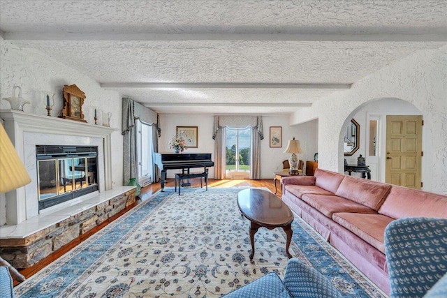 5880 Sugar Loaf Mountain Rd, Roanoke, VA 24018 - living area featuring wood finished floors, a textured wall, beamed ceiling, a fireplace, and arched walkways