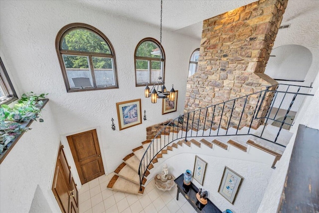 5880 Sugar Loaf Mountain Rd, Roanoke, VA 24018 - stairs with a textured wall, tile patterned floors, a textured ceiling, and a chandelier