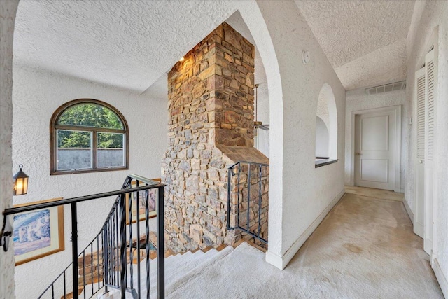 5880 Sugar Loaf Mountain Rd, Roanoke, VA 24018 - hall with a textured ceiling, a textured wall, carpet floors, an upstairs landing, and arched walkways