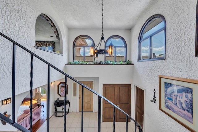 5880 Sugar Loaf Mountain Rd, Roanoke, VA 24018 - stairway featuring a textured wall, a chandelier, tile patterned flooring, and a textured ceiling
