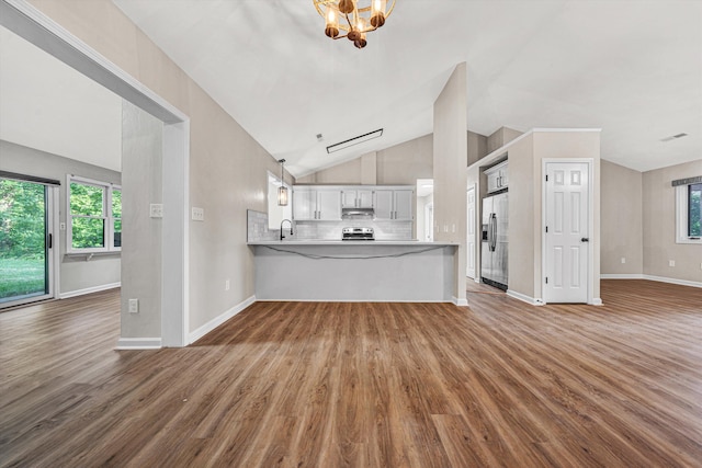 8757 Bent Mountain Rd, Roanoke, VA 24018 - unfurnished living room featuring wood finished floors, vaulted ceiling, plenty of natural light, and a chandelier