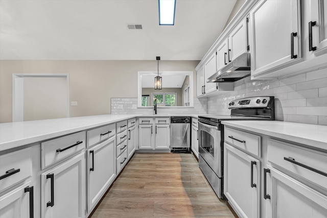 8757 Bent Mountain Rd, Roanoke, VA 24018 - kitchen with appliances with stainless steel finishes, under cabinet range hood, light countertops, decorative backsplash, and white cabinets