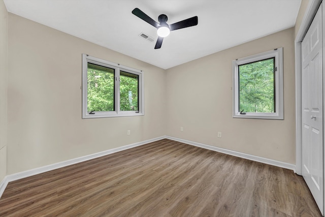 8757 Bent Mountain Rd, Roanoke, VA 24018 - unfurnished bedroom with a closet, multiple windows, wood finished floors, and a ceiling fan