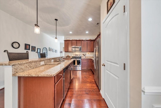 8355 Leighburn Dr, Roanoke, VA 24019 - kitchen featuring appliances with stainless steel finishes, dark wood-type flooring, light stone counters, recessed lighting, and pendant lighting