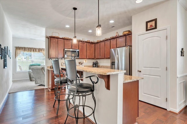 8355 Leighburn Dr, Roanoke, VA 24019 - kitchen with appliances with stainless steel finishes, a kitchen bar, light stone countertops, pendant lighting, and dark wood-style floors