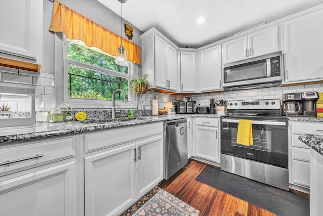 2343 Circle Dr SW, Roanoke, VA 24018 - kitchen with stainless steel appliances, white cabinets, dark wood-type flooring, decorative backsplash, and hanging light fixtures