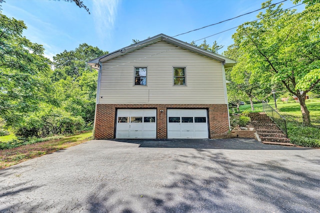2343 Circle Dr SW, Roanoke, VA 24018 - view of property exterior featuring brick siding, driveway, an attached garage, and stairs