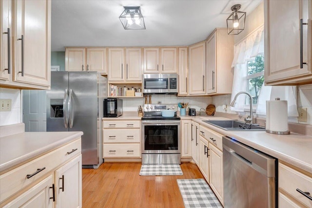 245 Queen Regent Ct, Blue Ridge, VA 24064 - kitchen with appliances with stainless steel finishes, light wood-style flooring, light countertops, decorative backsplash, and light brown cabinets