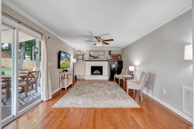245 Queen Regent Ct, Blue Ridge, VA 24064 - living room featuring wood finished floors, a fireplace, ceiling fan, and ornamental molding
