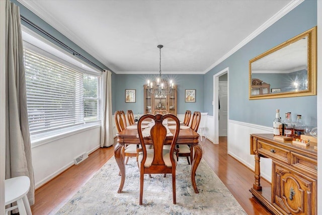 245 Queen Regent Ct, Blue Ridge, VA 24064 - dining area featuring a chandelier, wood finished floors, a wainscoted wall, and crown molding