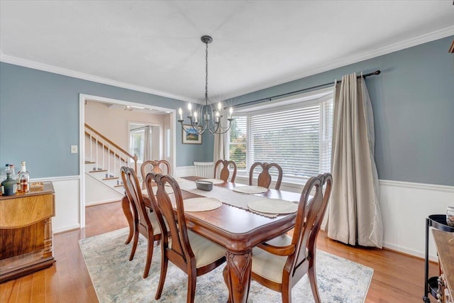 245 Queen Regent Ct, Blue Ridge, VA 24064 - dining area featuring stairs, a chandelier, a wainscoted wall, ornamental molding, and light wood-style flooring