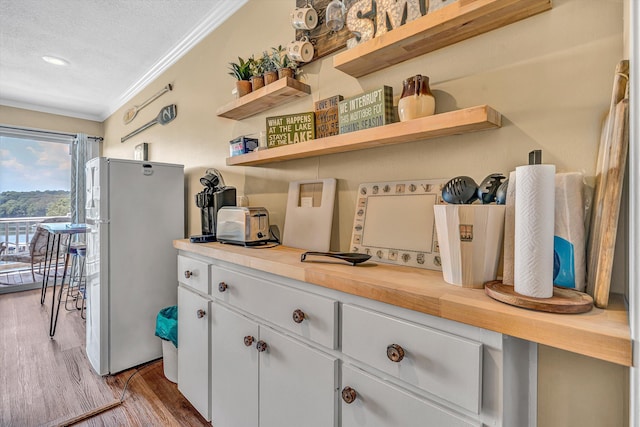 1085 Bluewater Dr Unit 220, Moneta, VA 24121 - kitchen with freestanding refrigerator, open shelves, ornamental molding, wood finished floors, and a textured ceiling