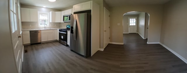 214 E Madison St, Covington, VA 24426 - kitchen featuring appliances with stainless steel finishes, arched walkways, dark wood finished floors, and white cabinets