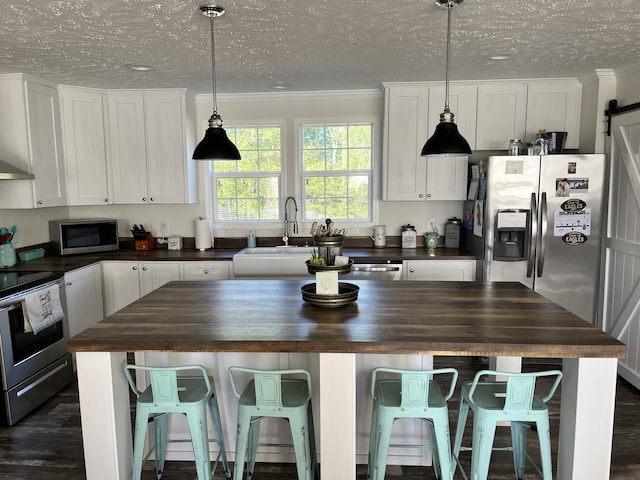 1148 Chapel View Ln, Goodview, VA 24095 - kitchen with butcher block countertops, appliances with stainless steel finishes, white cabinetry, crown molding, and a textured ceiling
