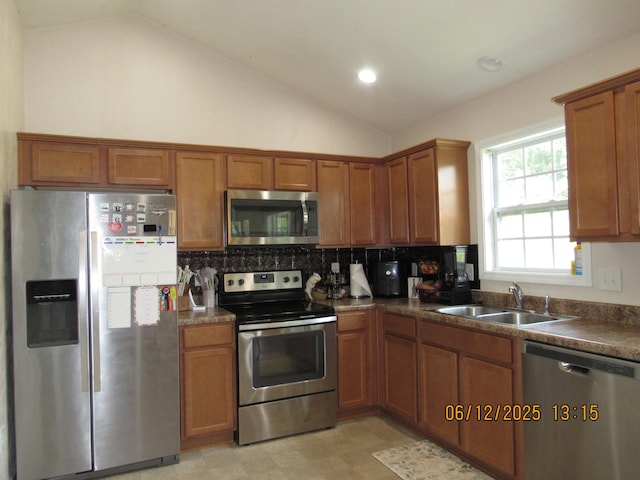 5605 Prunty Dr, Salem, VA 24153 - kitchen featuring appliances with stainless steel finishes, lofted ceiling, brown cabinetry, backsplash, and dark countertops