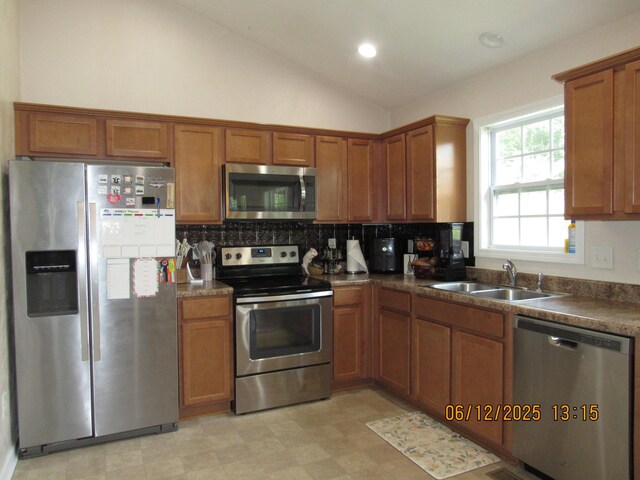 5605 Prunty Dr, Salem, VA 24153 - kitchen featuring stainless steel appliances, brown cabinets, tasteful backsplash, dark countertops, and lofted ceiling