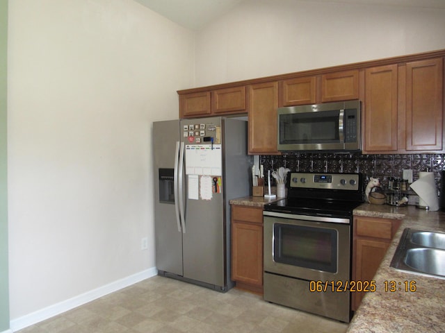 5605 Prunty Dr, Salem, VA 24153 - kitchen with appliances with stainless steel finishes, brown cabinets, tasteful backsplash, lofted ceiling, and light floors