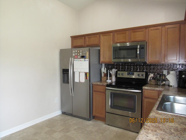 5605 Prunty Dr, Salem, VA 24153 - kitchen with stainless steel appliances, brown cabinets, tasteful backsplash, light flooring, and lofted ceiling