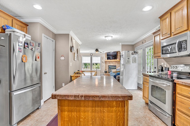 1060 Marble Creek Ct, Lynch Station, VA 24571 - kitchen with appliances with stainless steel finishes, a center island, crown molding, healthy amount of natural light, and a fireplace
