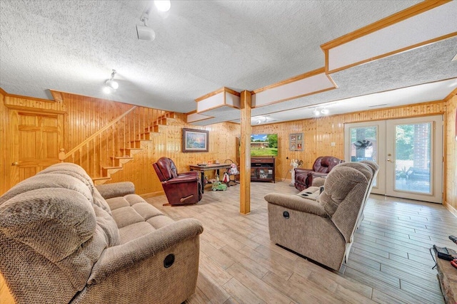 3203 Bradshaw Rd, Salem, VA 24153 - living area featuring stairs, wood walls, light wood-style floors, a textured ceiling, and french doors