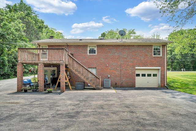 3203 Bradshaw Rd, Salem, VA 24153 - rear view of property featuring driveway, an attached garage, a wooden deck, brick siding, and stairs