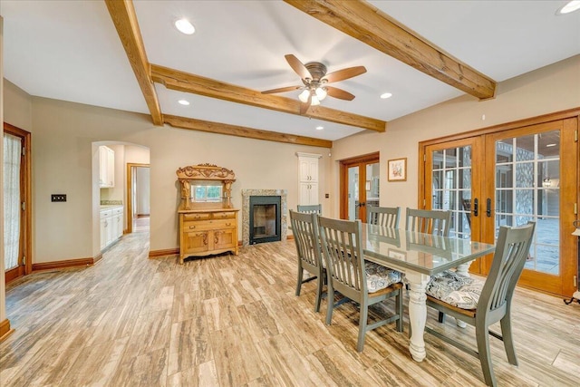 223 Moonriver Ln, Moneta, VA 24121 - dining room with french doors, arched walkways, light wood-style flooring, a fireplace, and beamed ceiling