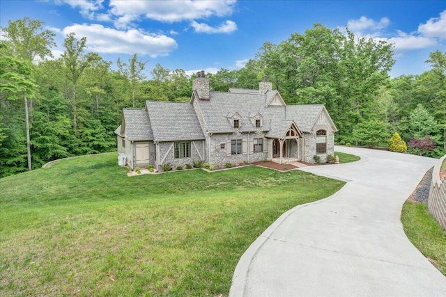 223 Moonriver Ln, Moneta, VA 24121 - tudor house featuring stone siding, a chimney, a front yard, and concrete driveway
