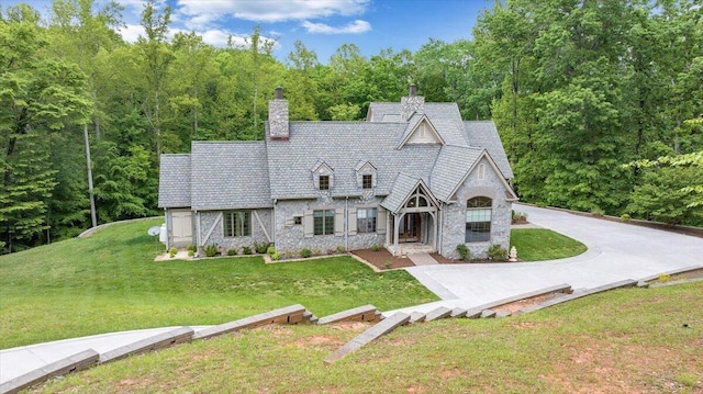 223 Moonriver Ln, Moneta, VA 24121 - tudor home with stone siding, a front yard, and a chimney