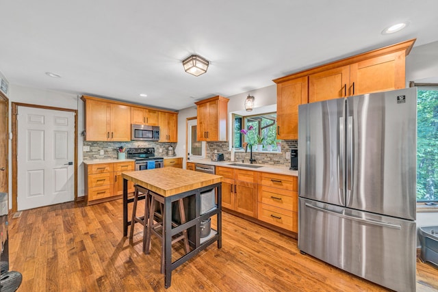 7102 Crown Rd, Roanoke, VA 24018 - kitchen with appliances with stainless steel finishes, wood finished floors, light countertops, decorative backsplash, and recessed lighting