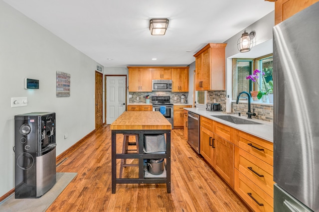 7102 Crown Rd, Roanoke, VA 24018 - kitchen with stainless steel appliances, light countertops, tasteful backsplash, light wood-style flooring, and brown cabinetry