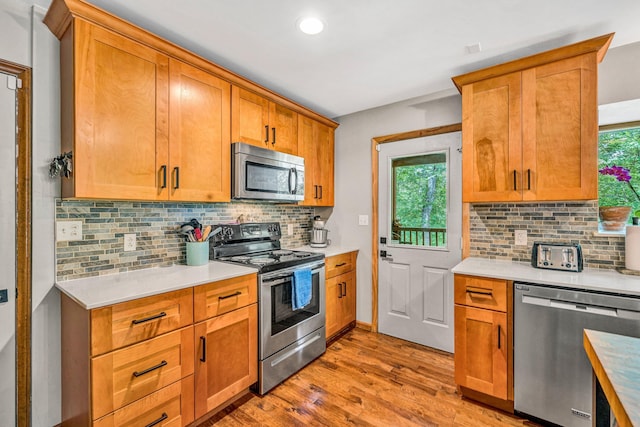 7102 Crown Rd, Roanoke, VA 24018 - kitchen with stainless steel appliances, light wood-style floors, light countertops, decorative backsplash, and recessed lighting
