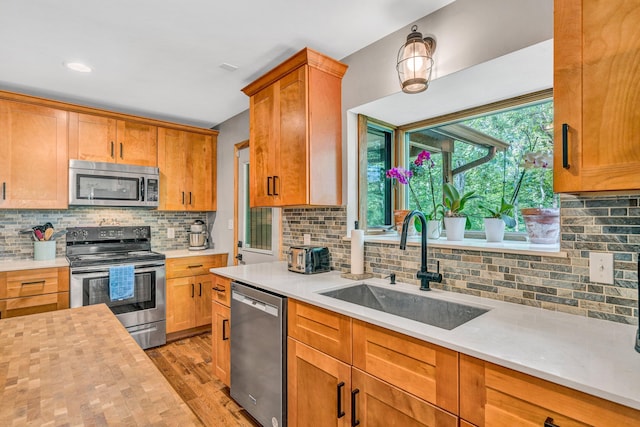7102 Crown Rd, Roanoke, VA 24018 - kitchen featuring appliances with stainless steel finishes, light countertops, light wood-type flooring, and tasteful backsplash