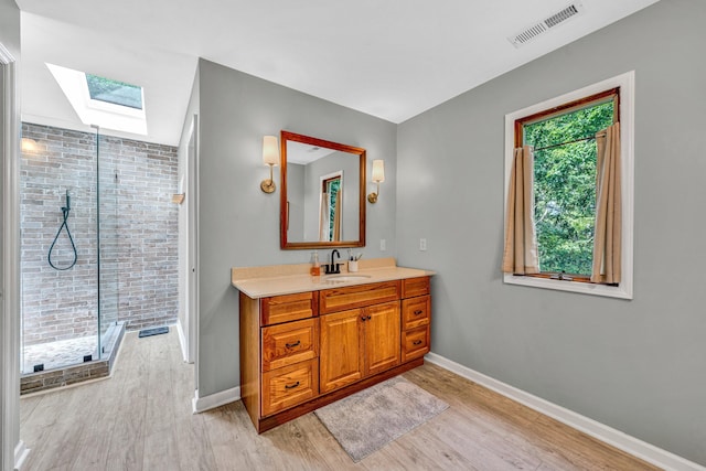 7102 Crown Rd, Roanoke, VA 24018 - bathroom with a skylight, vanity, a stall shower, and wood finished floors