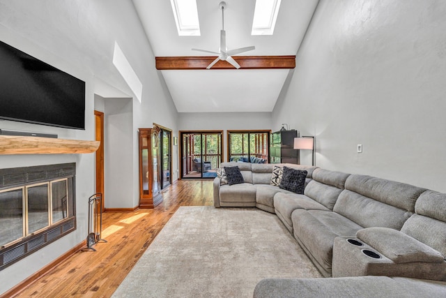 7102 Crown Rd, Roanoke, VA 24018 - living room featuring a skylight, high vaulted ceiling, light wood-style floors, a glass covered fireplace, and ceiling fan
