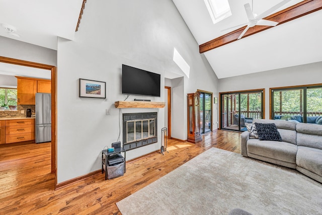 7102 Crown Rd, Roanoke, VA 24018 - living area with a skylight, a glass covered fireplace, high vaulted ceiling, ceiling fan, and light wood-style floors