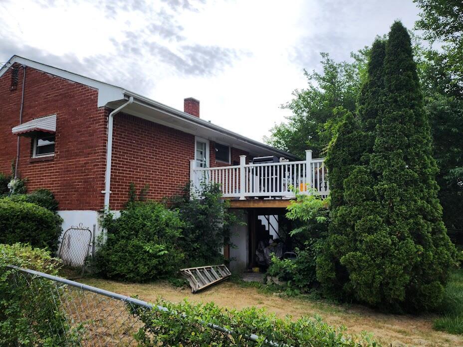 3038 Cove Rd NW, Roanoke, VA 24017 - view of home's exterior featuring brick siding, a wooden deck, and a chimney