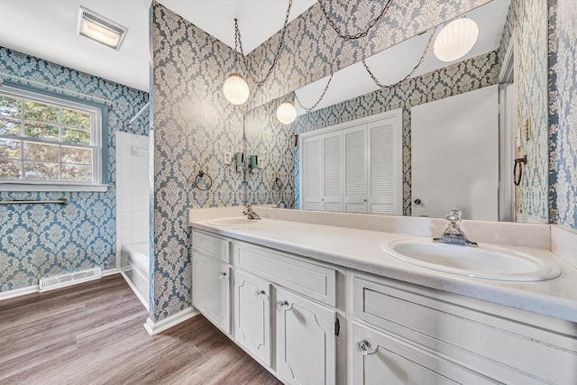 5428 Sweetfern Dr, Roanoke, VA 24019 - full bathroom with double vanity, wood finished floors, wallpapered walls, shower / bath combination, and a closet