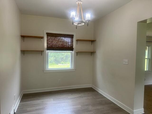 2327 Horsepasture Price Rd, Ridgeway, VA 24148 - empty room with healthy amount of natural light, wood finished floors, and a chandelier