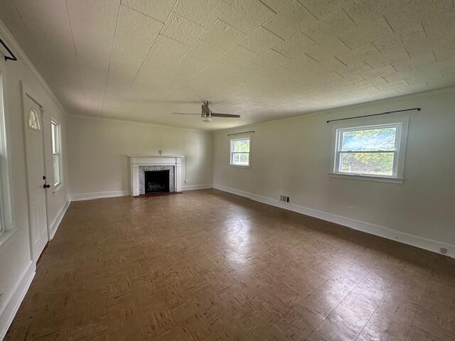 2327 Horsepasture Price Rd, Ridgeway, VA 24148 - unfurnished living room featuring ceiling fan, a fireplace with flush hearth, and ornamental molding