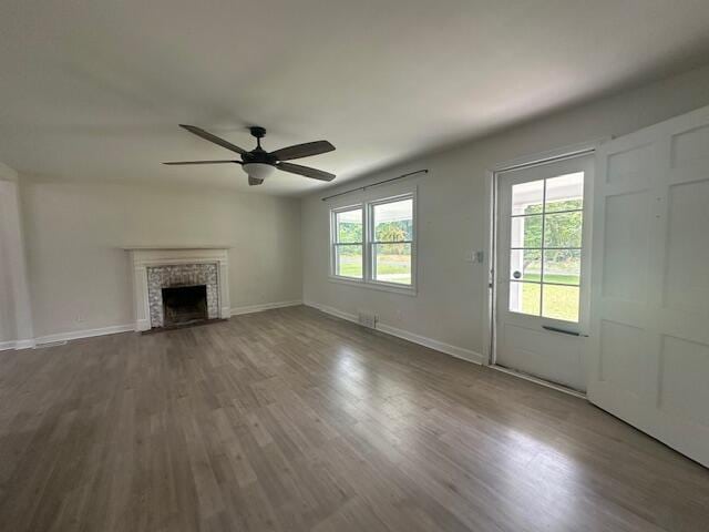 2327 Horsepasture Price Rd, Ridgeway, VA 24148 - unfurnished living room with a ceiling fan, wood finished floors, and a fireplace with flush hearth