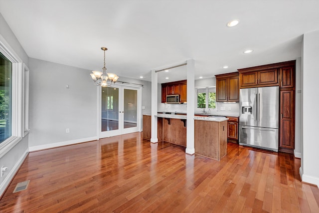 571 Cary Rd, Pilot, VA 24138 - kitchen with stainless steel appliances, light countertops, a chandelier, hardwood / wood-style flooring, and decorative light fixtures