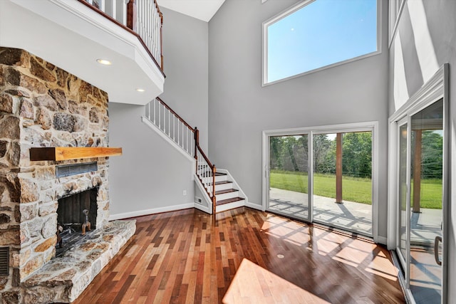 571 Cary Rd, Pilot, VA 24138 - unfurnished living room featuring a high ceiling, hardwood / wood-style floors, a fireplace, and stairs
