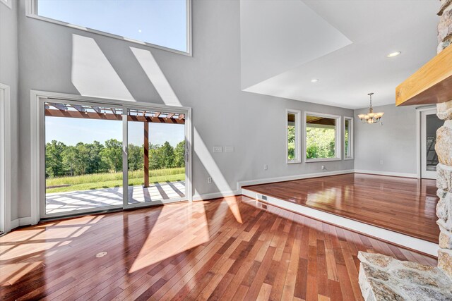 571 Cary Rd, Pilot, VA 24138 - unfurnished living room with a chandelier, a towering ceiling, hardwood / wood-style flooring, and recessed lighting