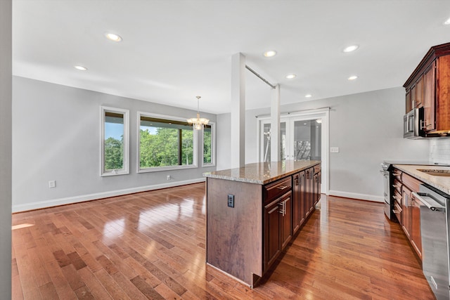 571 Cary Rd, Pilot, VA 24138 - kitchen with appliances with stainless steel finishes, a chandelier, wood-type flooring, light stone counters, and a center island