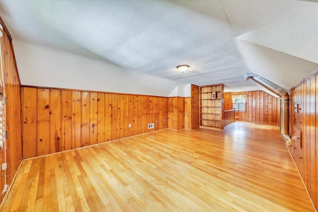 2728 Lansing Dr SW, Roanoke, VA 24015 - additional living space with light wood finished floors, lofted ceiling, a textured ceiling, and wooden walls