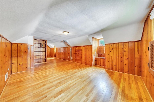 2728 Lansing Dr SW, Roanoke, VA 24015 - additional living space featuring wood walls, hardwood / wood-style floors, a textured ceiling, and lofted ceiling