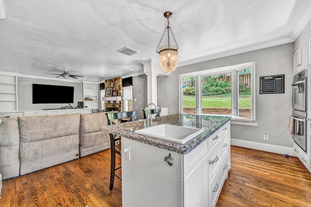 2410 Cornwallis Ave SE, Roanoke, VA 24014 - kitchen featuring open floor plan, a kitchen bar, ceiling fan, decorative columns, and stainless steel double oven