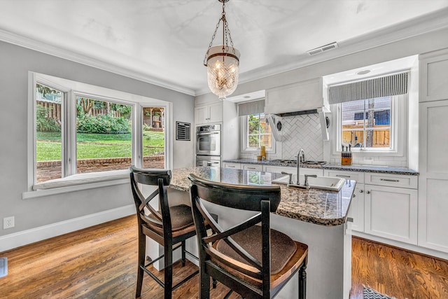 2410 Cornwallis Ave SE, Roanoke, VA 24014 - kitchen featuring appliances with stainless steel finishes, a breakfast bar area, backsplash, dark stone counters, and crown molding
